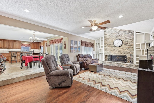 living room with lofted ceiling, light hardwood / wood-style floors, a textured ceiling, a brick fireplace, and built in shelves