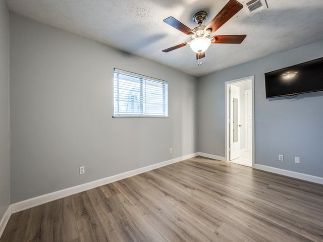 empty room with hardwood / wood-style floors, a textured ceiling, and ceiling fan