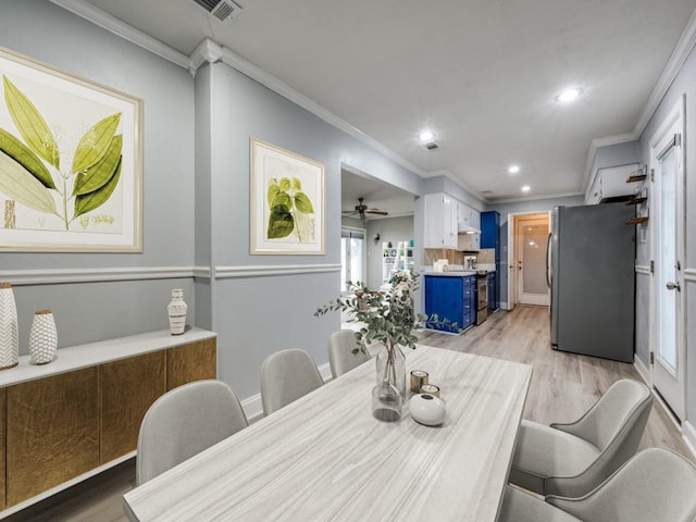 dining space featuring crown molding and light hardwood / wood-style floors