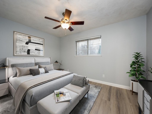 bedroom with ceiling fan and wood-type flooring