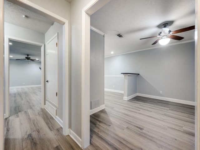 hall with crown molding and light hardwood / wood-style floors