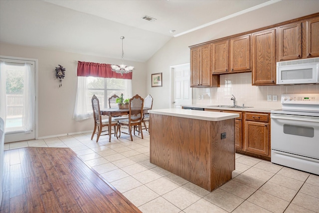 kitchen with sink, decorative light fixtures, light tile patterned floors, white appliances, and decorative backsplash