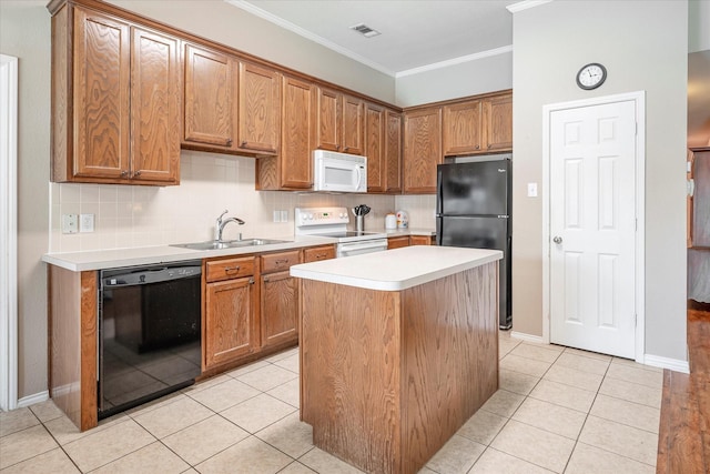 kitchen featuring sink, light tile patterned flooring, black appliances, and a kitchen island