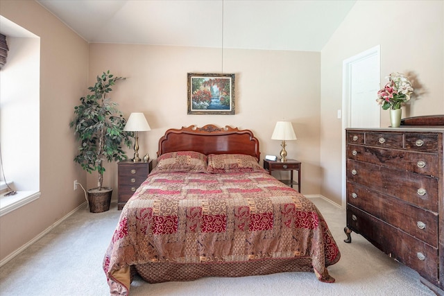 bedroom featuring lofted ceiling and light carpet