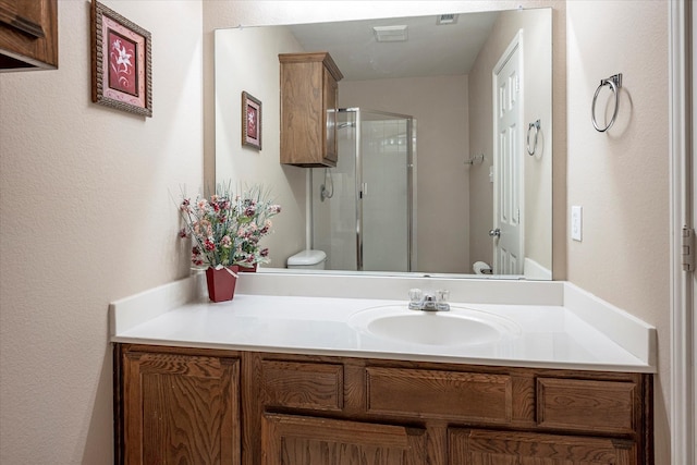 bathroom with vanity, toilet, and a shower with shower door