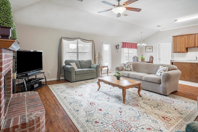 living room featuring lofted ceiling, dark hardwood / wood-style floors, and ceiling fan with notable chandelier