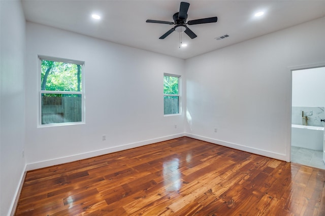 spare room featuring dark wood-type flooring and a healthy amount of sunlight