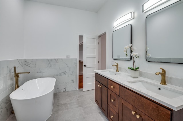 bathroom featuring vanity, tile walls, and a tub