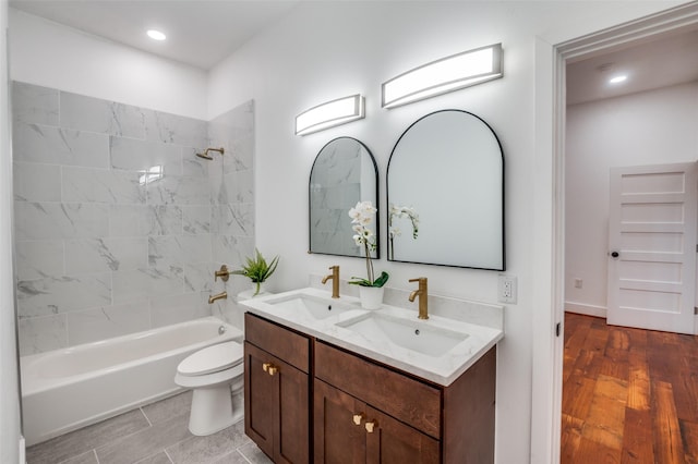 full bathroom with vanity, tiled shower / bath combo, wood-type flooring, and toilet