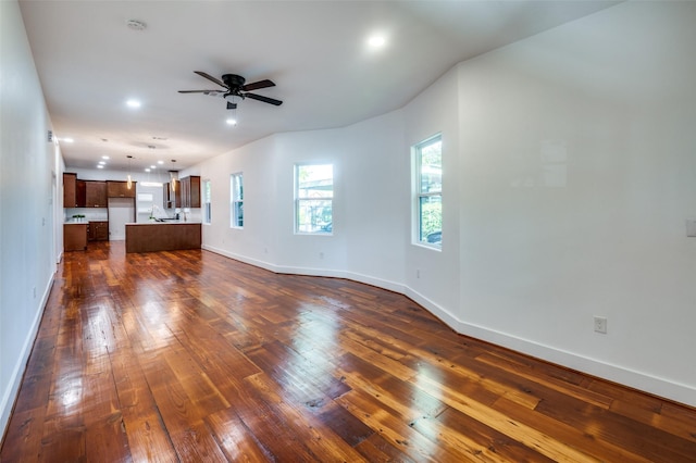 unfurnished living room featuring ceiling fan and dark hardwood / wood-style flooring