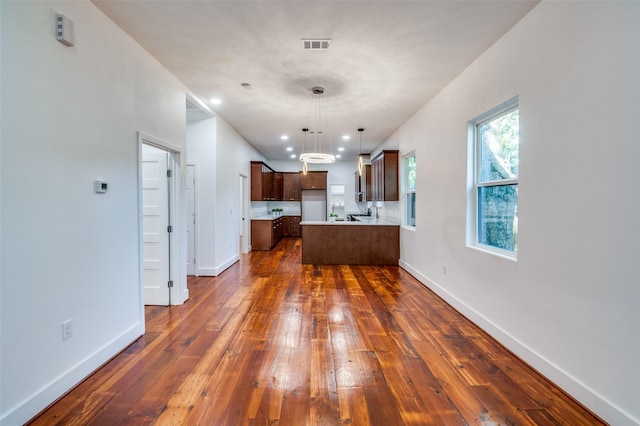 kitchen featuring a center island, decorative light fixtures, and dark hardwood / wood-style flooring