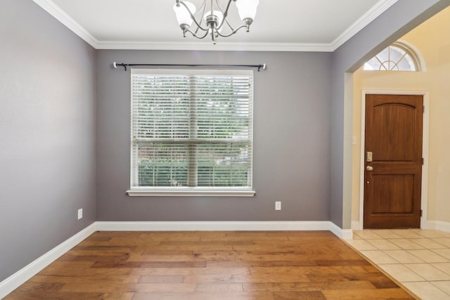 foyer entrance with an inviting chandelier, crown molding, and hardwood / wood-style flooring