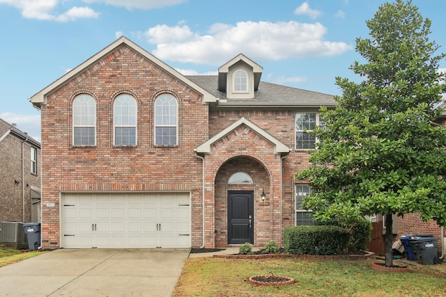 view of front of home with a garage, a front yard, and central air condition unit