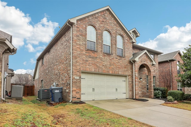 view of front of property featuring a garage, a front lawn, and central air condition unit