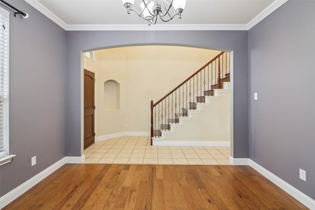 entrance foyer with crown molding, a chandelier, and light hardwood / wood-style flooring