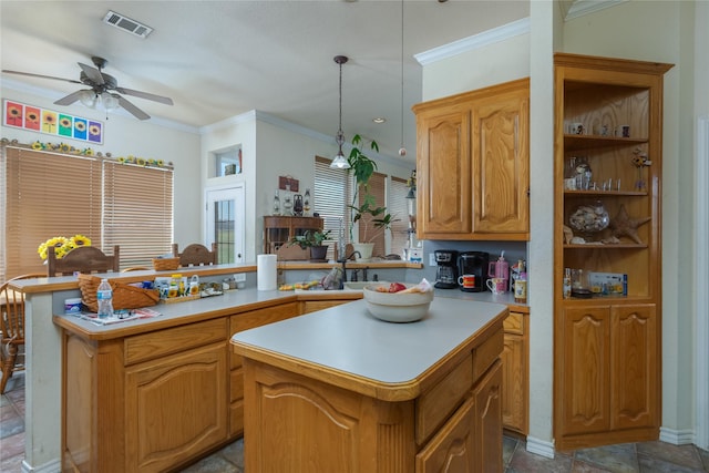 kitchen with ornamental molding, decorative light fixtures, and a center island