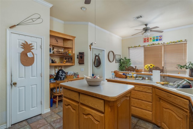 kitchen featuring ceiling fan, ornamental molding, black dishwasher, and a kitchen island