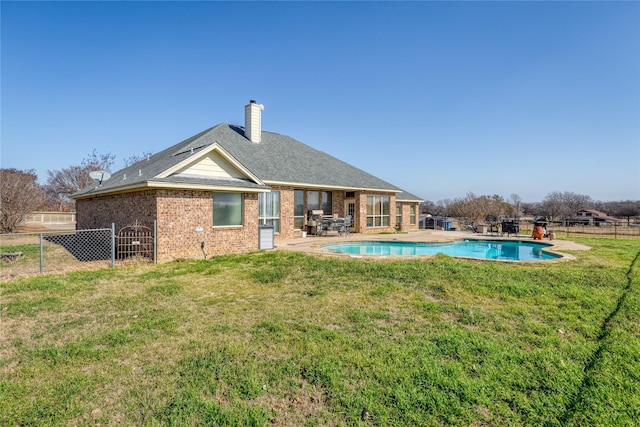 rear view of house with a patio and a lawn