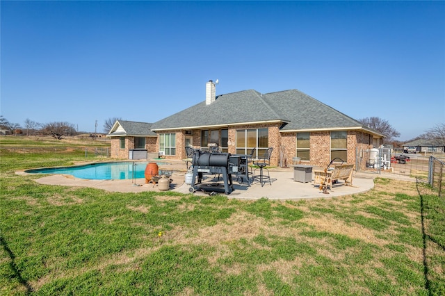 rear view of property featuring a yard, a fireplace, and a patio area