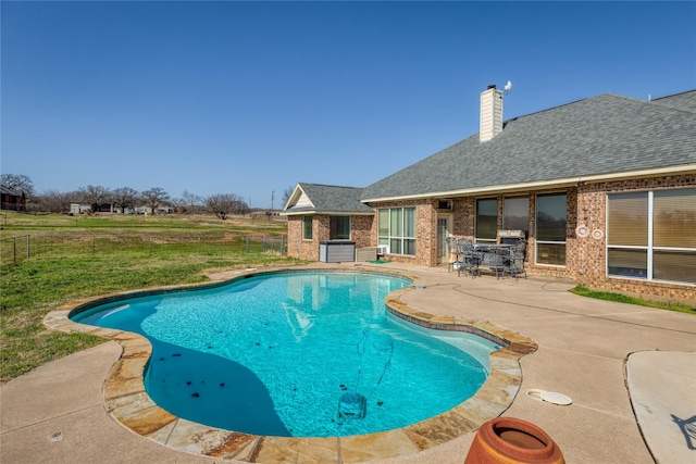 view of swimming pool featuring a patio and a yard