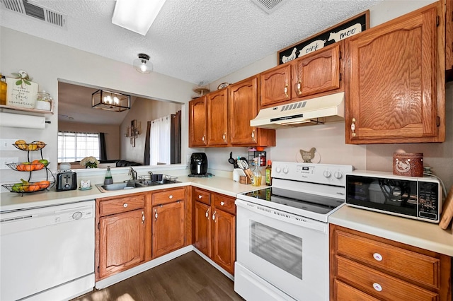 kitchen featuring sink, a chandelier, a textured ceiling, dark hardwood / wood-style flooring, and white appliances