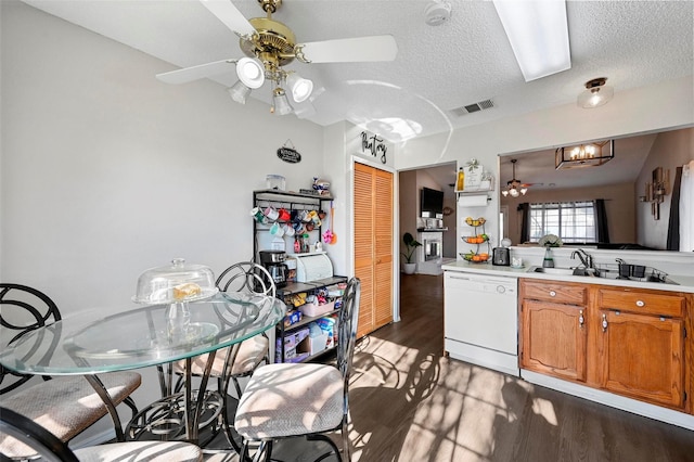 kitchen featuring sink, dark wood-type flooring, ceiling fan, white dishwasher, and a textured ceiling