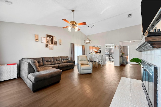 living room with ceiling fan, dark hardwood / wood-style flooring, and high vaulted ceiling