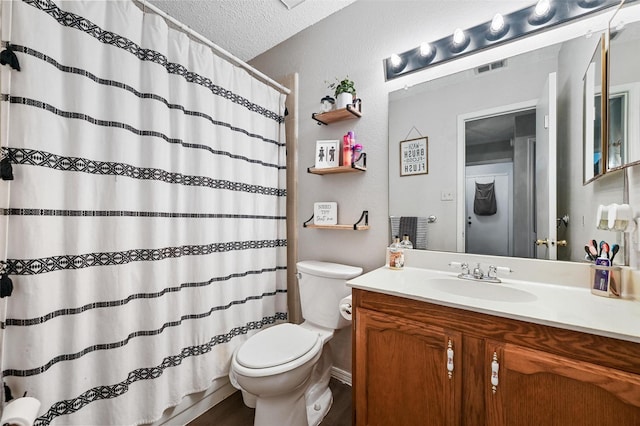 bathroom with a shower with curtain, vanity, a textured ceiling, and toilet