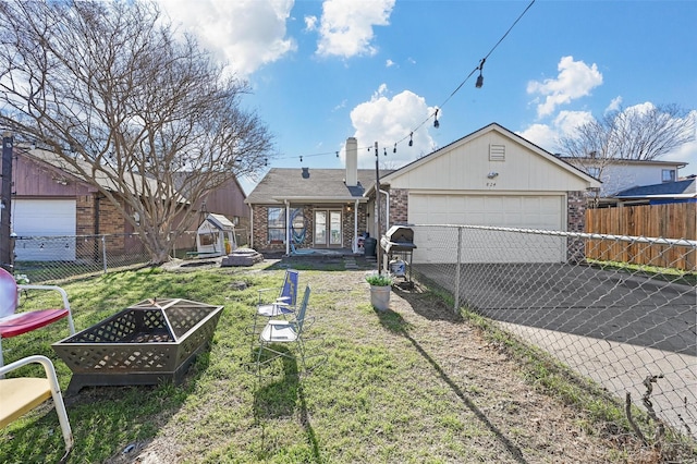 view of front of home with a garage, a fire pit, and a front yard