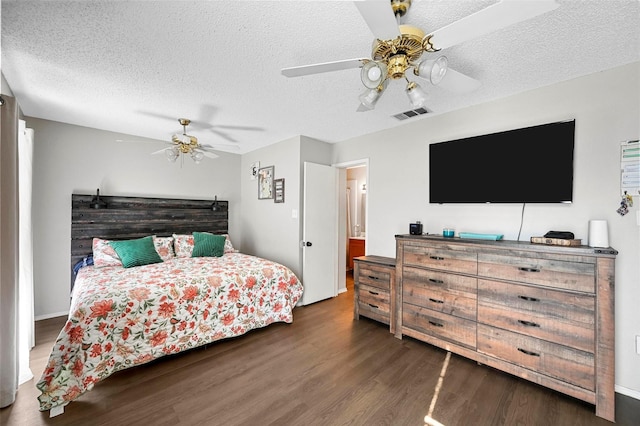 bedroom featuring dark hardwood / wood-style flooring, ceiling fan, and a textured ceiling