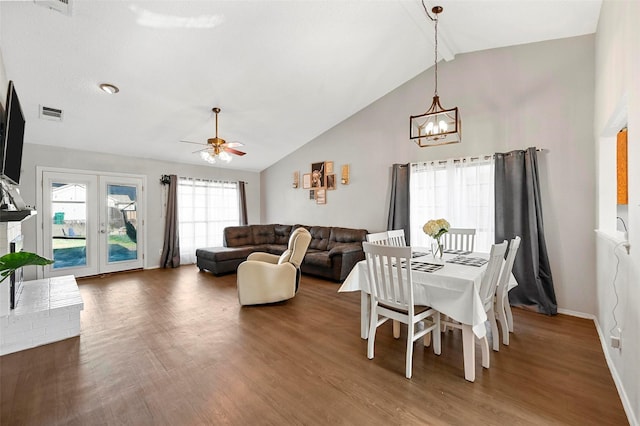 dining space featuring beam ceiling, high vaulted ceiling, dark hardwood / wood-style floors, ceiling fan with notable chandelier, and french doors