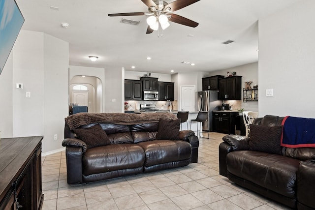 living room with light tile patterned flooring, ceiling fan, and sink