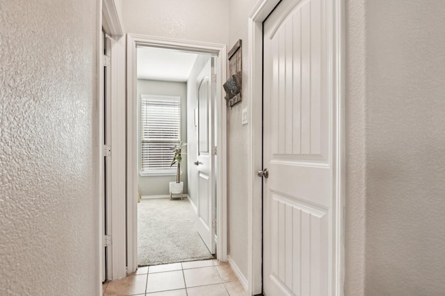 hall featuring light tile patterned floors