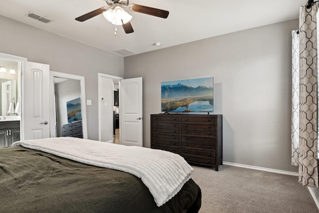 carpeted bedroom with ensuite bath and ceiling fan