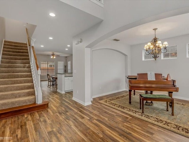 dining space featuring ceiling fan with notable chandelier and hardwood / wood-style floors