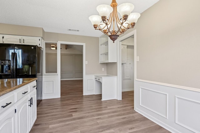 201 Trailwood Dr, Euless, TX 76039 - kitchen with hanging light fixtures, white cabinetry, dark stone counters, and light hardwood / wood-style flooring