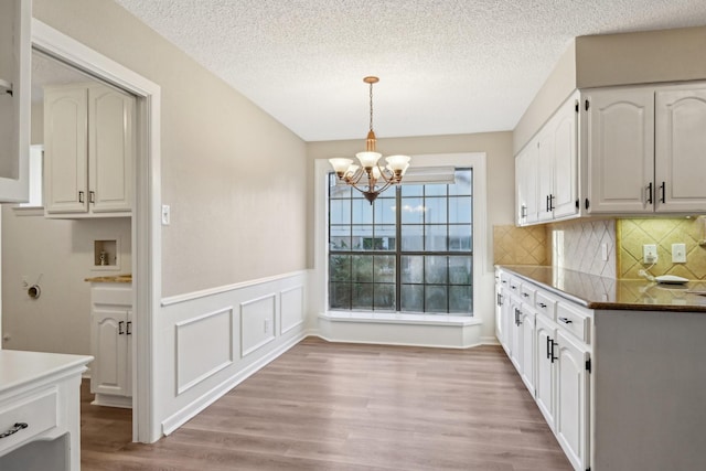 201 Trailwood Dr, Euless, TX 76039 - kitchen featuring tasteful backsplash, white cabinetry, light wood-type flooring, hanging light fixtures, and an inviting chandelier