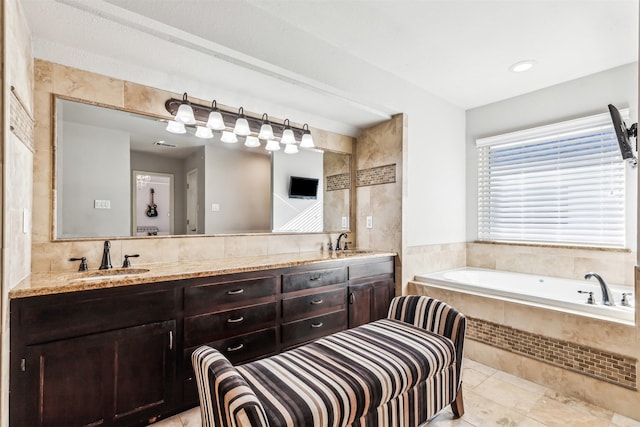 bathroom with tile patterned flooring, vanity, and a relaxing tiled tub