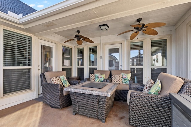 view of patio / terrace featuring ceiling fan and an outdoor living space with a fire pit