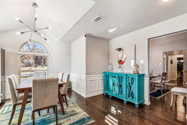 dining area with lofted ceiling, a notable chandelier, and dark wood-type flooring