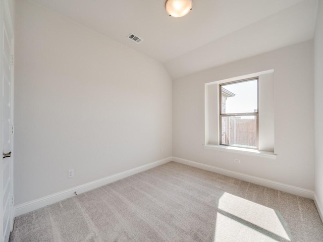 carpeted spare room with lofted ceiling