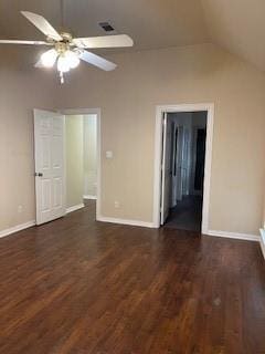 interior space with a ceiling fan, vaulted ceiling, baseboards, and dark wood-style floors