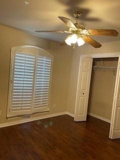 unfurnished bedroom featuring a ceiling fan, a closet, baseboards, and dark wood-type flooring