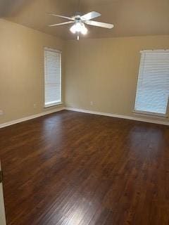 spare room featuring ceiling fan, dark wood-type flooring, and baseboards