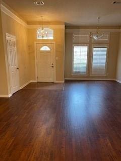 foyer with dark hardwood / wood-style flooring, ornamental molding, and an inviting chandelier