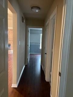 corridor with dark wood-style floors and baseboards