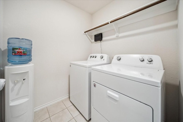 clothes washing area featuring light tile patterned flooring and washer and clothes dryer