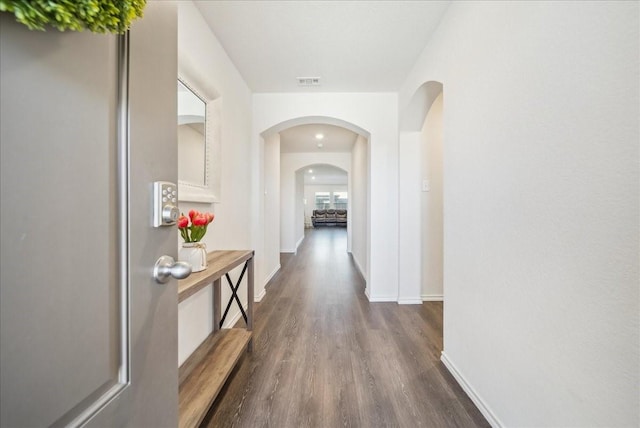 corridor with dark hardwood / wood-style flooring