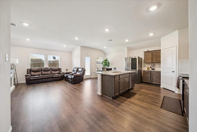 kitchen featuring sink, dark wood-type flooring, appliances with stainless steel finishes, light stone countertops, and vaulted ceiling