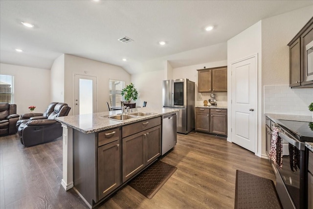 kitchen with sink, dark wood-type flooring, appliances with stainless steel finishes, a wealth of natural light, and an island with sink